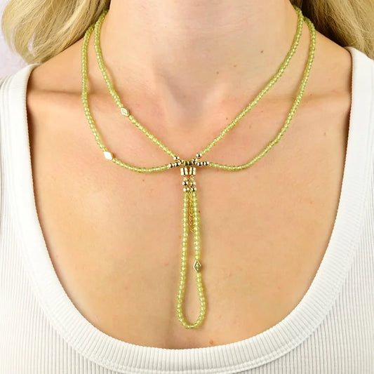 Necklace with green beads and gold accents worn by a person
