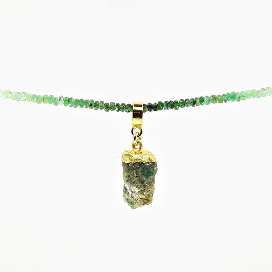 Necklace with green gemstones and a gold pendant on a white background