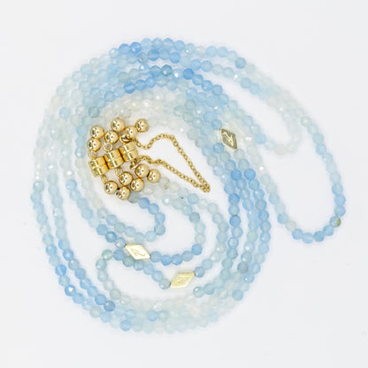 Long beaded necklace with gold accents on a white background