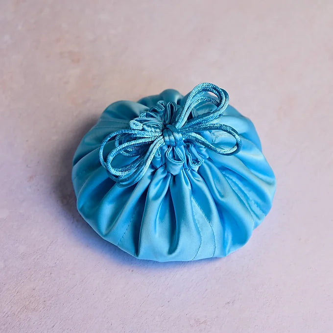 Blue satin drawstring pouch on a beige background