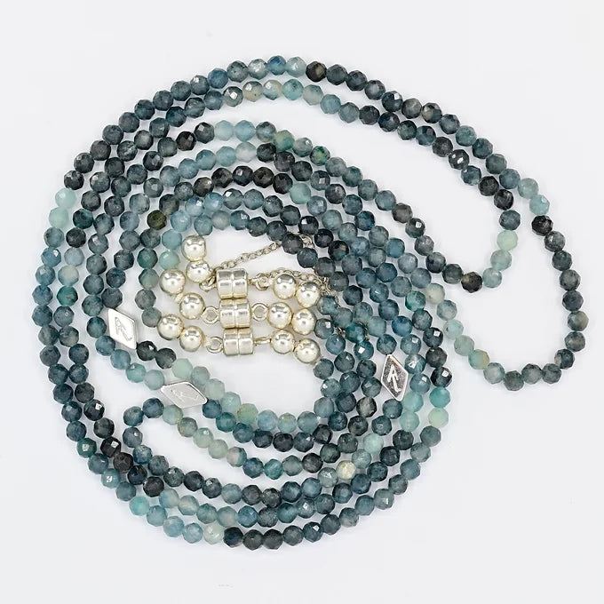 Stack of blue and green beaded necklaces on a white background