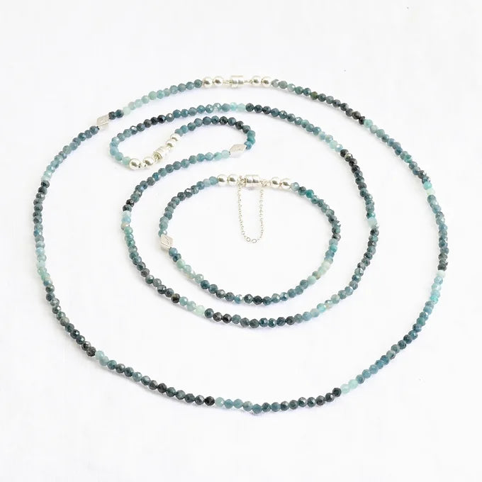 Beaded necklace with blue and green stones on a white background