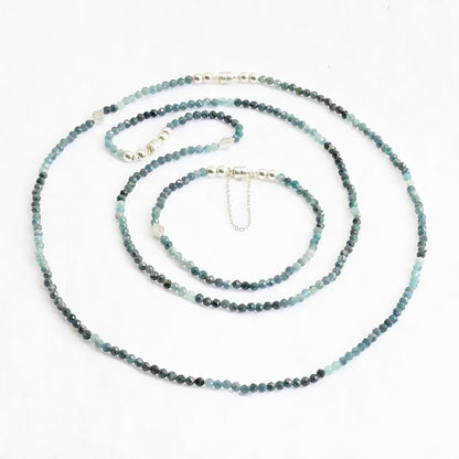 Beaded necklace with blue and green stones on a white background