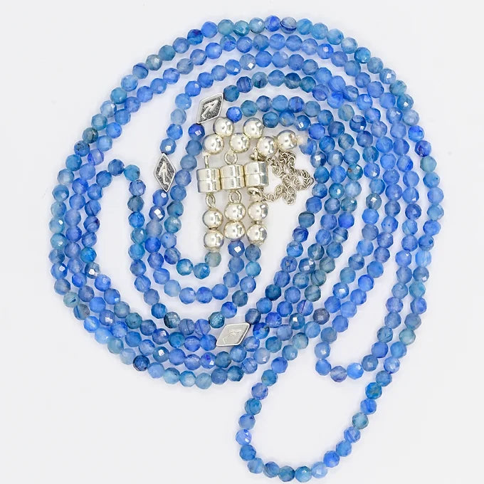 Blue beaded necklace with silver clasp on a white background