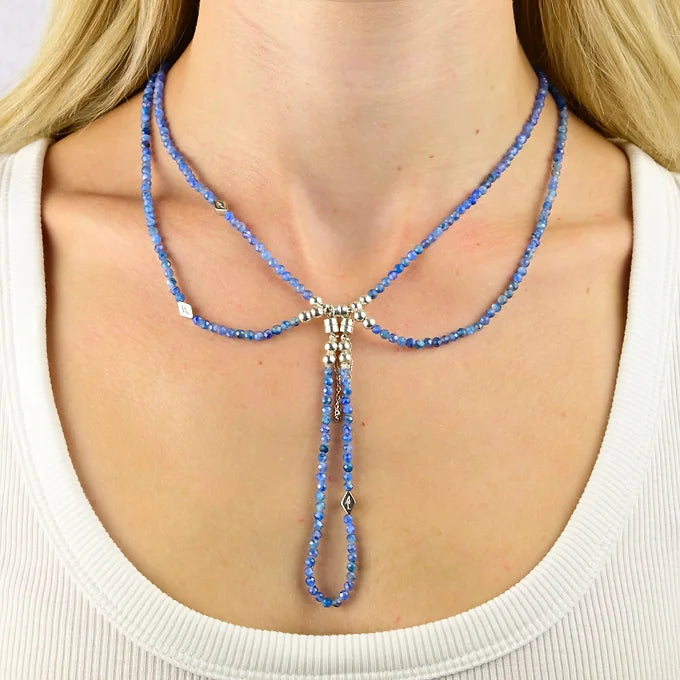 Blue beaded necklace worn by a person on a white background