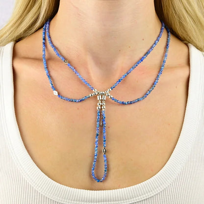 Blue beaded necklace worn by a person on a white background