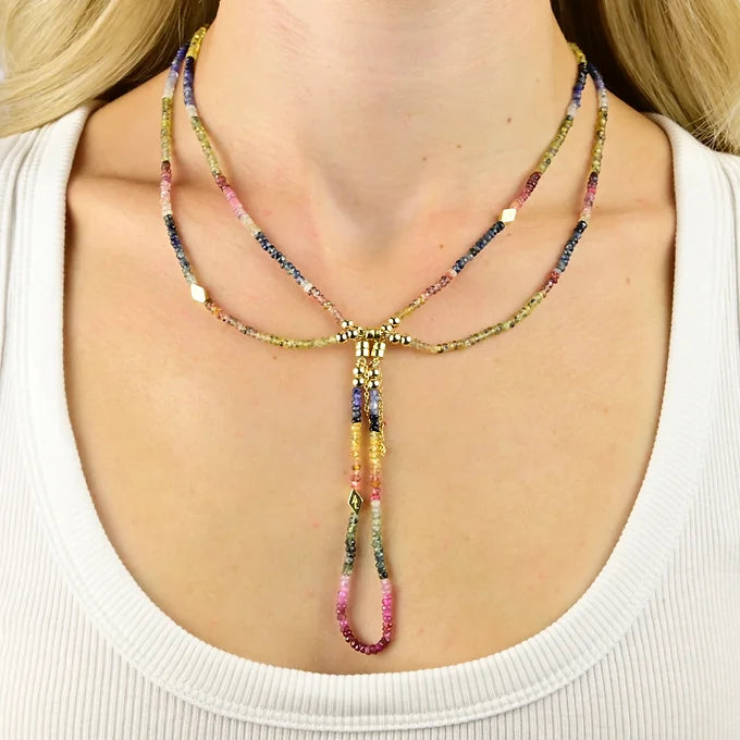 Multicolored beaded necklace on a person wearing a white top