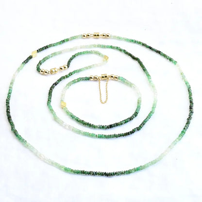Green beaded necklace with gold accents on a white background