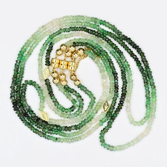 Green beaded necklace with gold accents on a white background
