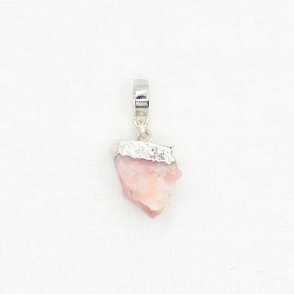 Pink stone pendant with silver accents on a white background