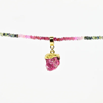 Necklace with multicolored beads and a pink pendant on a white background