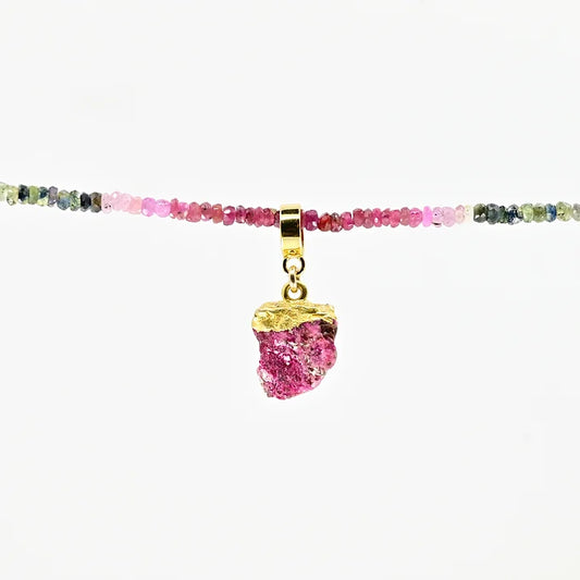 Necklace with multicolored beads and a pink pendant on a white background