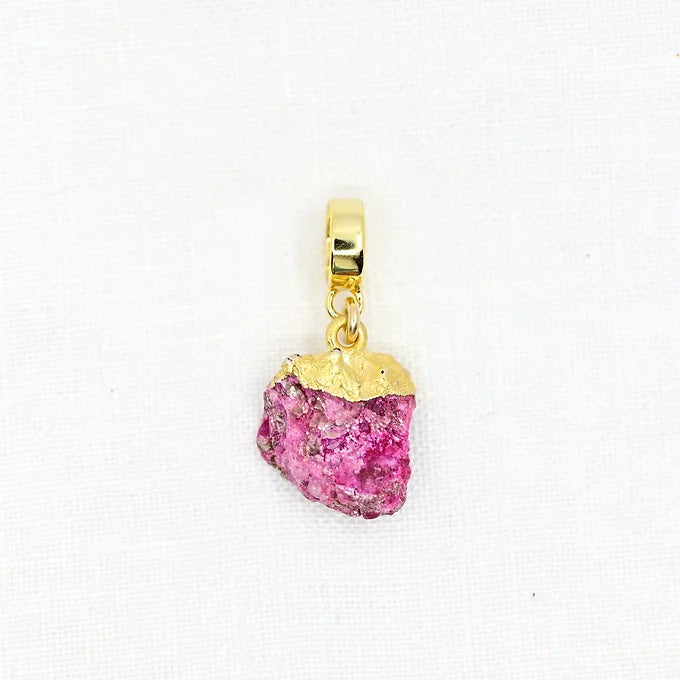 Gold pendant with a pink gemstone on a white background