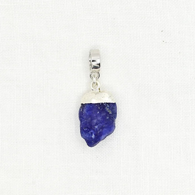 Pendant with blue stone and silver setting on a white background