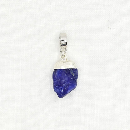 Pendant with blue stone and silver setting on a white background
