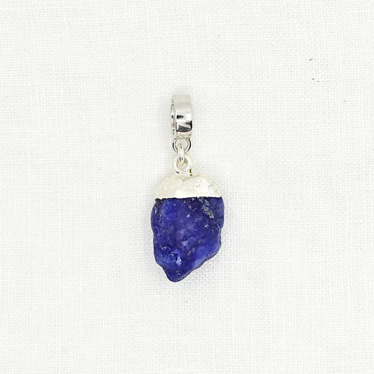 Pendant with blue stone and silver setting on a white background