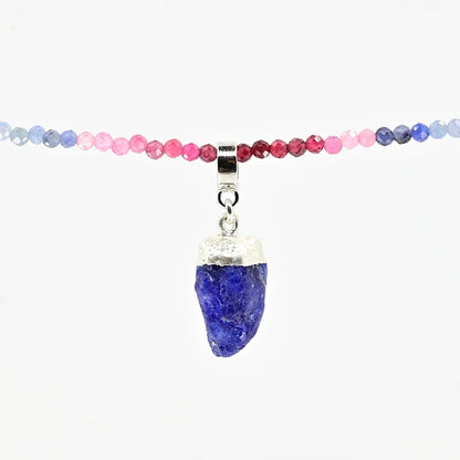Necklace with multicolored beads and a blue pendant on a white background