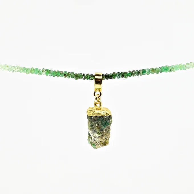Necklace with green gemstones and a gold pendant on a white background