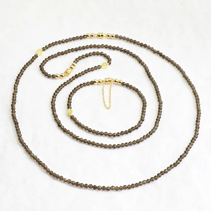 Brown beaded necklace with gold clasp on a white background