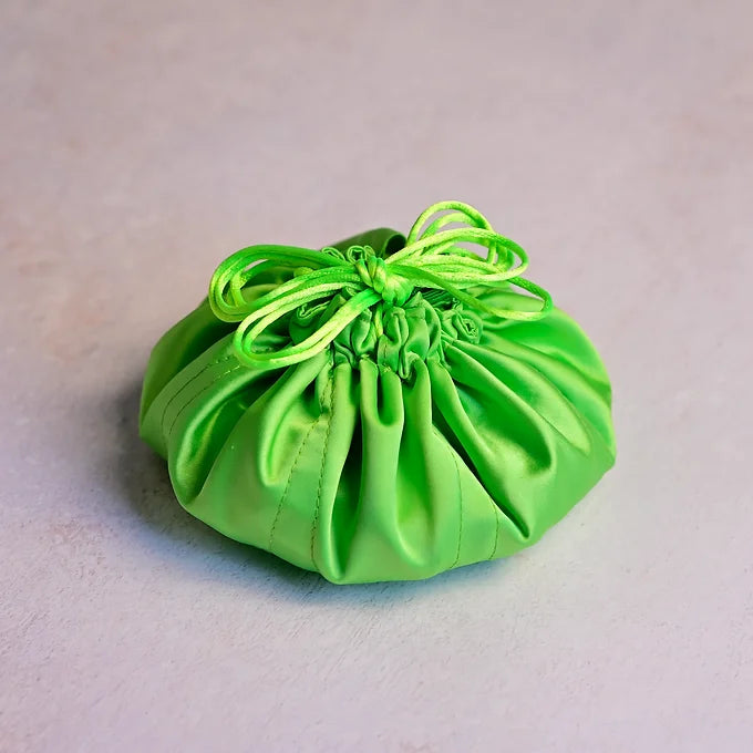 Green drawstring bag with green string on a light gray background