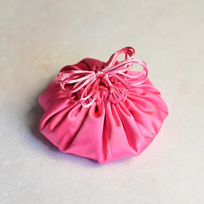 Pink drawstring bag on a light gray background