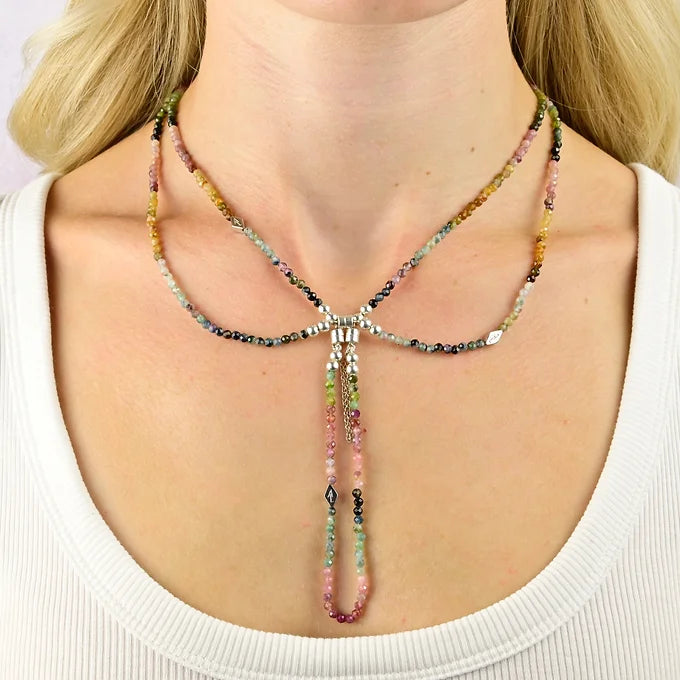 Multicolored beaded necklace on a person wearing a white top