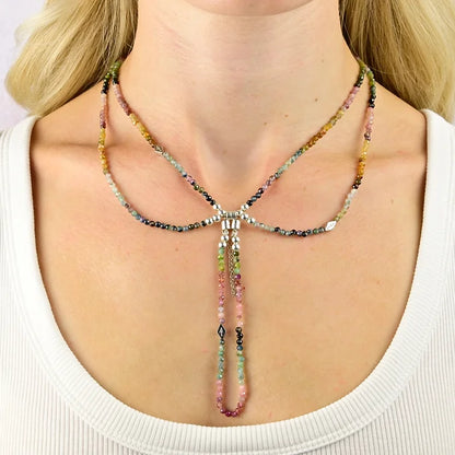 Multicolored beaded necklace on a person wearing a white top